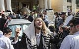 An ultra-Orthodox man prays at the scene of an attack in the Har Nof neighborhood of Jerusalem, November 18, 2014. (photo credit: AFP/Jack Guez)
