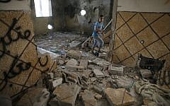 A relative of Abdelrahman Shaludi, a Palestinian who killed two Israelis with his car last month, walks inside his family home after it was razed by Israeli authorities in the East Jerusalem neighborhood of Silwan, November 19, 2014. (photo credit: AFP/Ahmad Gharabli)