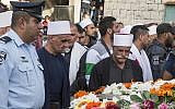 Friends, relatives and religious dignitaries mourn near the coffin of Israeli police officer Zidan Saif, 30, a member of Israel's Druze minority, during his funeral in his northern home village of Yanuh-Jat, on November 19, 2014. (photo credit: AFP/Jack Guez)