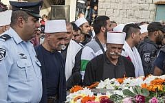 Friends, relatives and religious dignitaries mourn near the coffin of Israeli police officer Zidan Saif, 30, a member of Israel's Druze minority, during his funeral in his northern home village of Yanuh-Jat, on November 19, 2014. (photo credit: AFP/Jack Guez)
