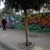 A Palestinian man walks past graffiti in Gaza City on November 21, 2014. For youth in the Gaza Strip packed with 1.8 million people, graffiti is an important tool for self-expression and fighting back. (photo credit: AFP/MOHAMMED ABED)