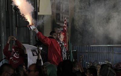 Arab-Israeli supporters of Bnei Sakhnin, the only Arab team in the Israeli Premier league, light flares as they cheer on their team during their football match against the predominantly Jewish Beitar Jerusalem club at the Doha Stadium in the northern Arab-Israeli town of Sakhnin on November 23, 2014. (Photo credit: AFP/ AHMED GHARABLI)