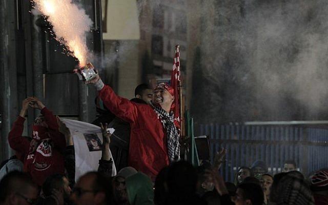 Arab-Israeli supporters of Bnei Sakhnin, the only Arab team in the Israeli Premier league, light flares as they cheer on their team during their football match against the predominantly Jewish Beitar Jerusalem club at the Doha Stadium in the northern Arab-Israeli town of Sakhnin on November 23, 2014. (Photo credit: AFP/ AHMED GHARABLI) Arab-Israeli supporters of Bnei Sakhnin, the only Arab team in the Israeli Premier league, light flares as they cheer on their team during their football match against the predominantly Jewish Beitar Jerusalem club at the Doha Stadium in the northern Arab-Israeli town of Sakhnin on November 23, 2014. (Photo credit: AFP/ AHMED GHARABLI)