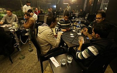 (FILES) - A file picture taken on November 15, 2014, Syrian men playing cards at a cafe in the Mogambo neighborhood on the government controlled side of Aleppo (photo credit: AFP/JOSEPH EID) (FILES) - A file picture taken on November 15, 2014, Syrian men playing cards at a cafe in the Mogambo neighborhood on the government controlled side of Aleppo (photo credit: AFP/JOSEPH EID)