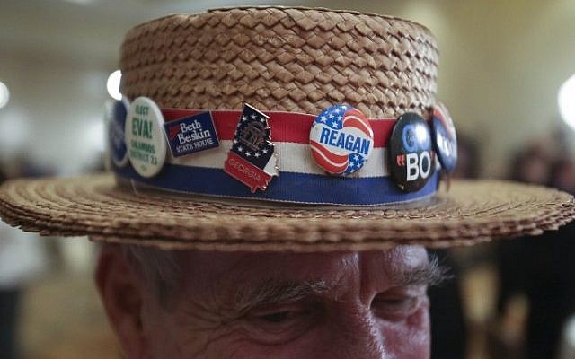 Hank Schwab of Atlanta (C), shows the campaign hat he's worn for the past 30 years at a gathering in support of Republican US Senate candidate David Perdue at the InterContinental Buckhead November 4, 2014 in Atlanta, Georgia. Perdue is running in a tight race against Democratic US Senate candidate Michelle Nunn (Photo credit: Jason Getz/Getty Images/AFP) Hank Schwab of Atlanta (C), shows the campaign hat he's worn for the past 30 years at a gathering in support of Republican US Senate candidate David Perdue at the InterContinental Buckhead November 4, 2014 in Atlanta, Georgia. Perdue is running in a tight race against Democratic US Senate candidate Michelle Nunn (Photo credit: Jason Getz/Getty Images/AFP)
