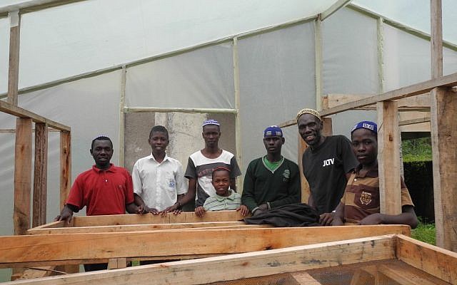 JJ Keki and his sons in a new drying area, which will protect the drying coffee beans from sudden rain showers and improve the quality of the coffee while cutting down on drying time. (Melanie Lidman/Times of Israel)