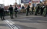 Police stand in front of banners reading 'Donate with every step, march' (top left), and '#Right against right' (top right), during a far-right march in Wunsiedel, southern Germany. Letters on the ground say 'Thanks for euro 2,500!' November 15, 2014. (photo credit: AP/dpa, Fricke)