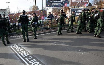 Police stand in front of banners reading 'Donate with every step, march' (top left), and '#Right against right' (top right), during a far-right march in Wunsiedel, southern Germany. Letters on the ground say 'Thanks for euro 2,500!' November 15, 2014. (photo credit: AP/dpa, Fricke)