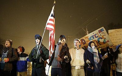 Protesters stand in front of the Ferguson Police Department, Wednesday, Nov. 26, 2014, in Ferguson, Mo. (AP Photo/David Goldman)