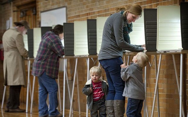 Debbie Baldwin fills out her ballot on Election Day with the company of her sons Joshua, 4, and Luke, 2, at Aberdeen School in Grand Rapids, Mich., Tuesday, Nov. 4, 2014. (photo credit: AP/The Grand Rapids Press, Chris Clark) Debbie Baldwin fills out her ballot on Election Day with the company of her sons Joshua, 4, and Luke, 2, at Aberdeen School in Grand Rapids, Mich., Tuesday, Nov. 4, 2014. (photo credit: AP/The Grand Rapids Press, Chris Clark)
