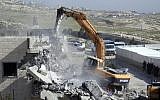File: Bulldozers of the Jerusalem municipality destroy a Palestinian house in the East Jerusalem neighborhood of Al-Tur on March 26, 2014, on the grounds that it was built without a construction permit. (photo credit: Sliman Khader/Flash90/File)