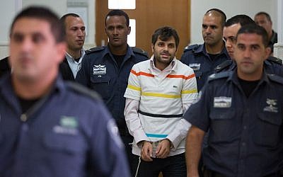 Police escort Yosef Haim Ben-David, one of the suspects in the murder of Muhammed Abu Khdeir, in the District Court in Jerusalem after his arrest in July, 2014. (Photo by Yonatan Sindel/Flash90)