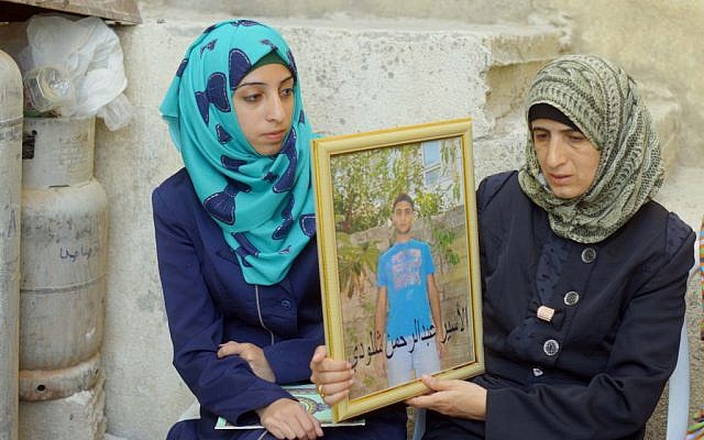 Female family members of Jerusalem terrorist Abdul Rahman Shaloudi hold up a portrait of him in Silwan, October 23, 2014 (photo credit: Sliman Khader/Flash90)