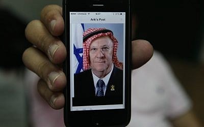 An iPhone logged into Facebook shows a user's post of a manipulated picture of President, Reuven Rivlin, with a keffiyeh. October 30, 2014. (Photo credit: Nati Shohat/Flash90) 