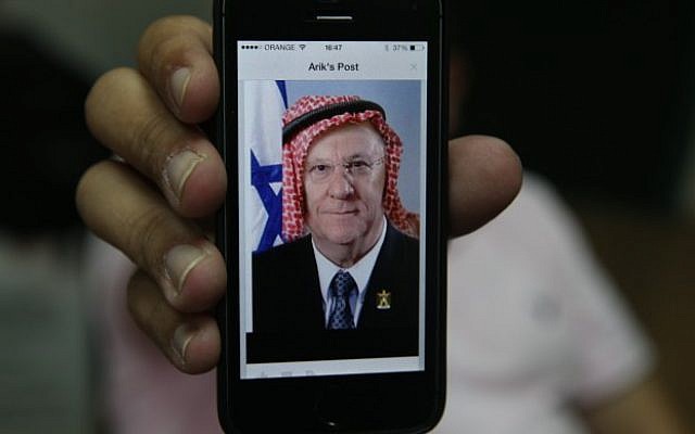 An iPhone logged into Facebook shows a user's post of a manipulated picture of President, Reuven Rivlin, with a keffiyeh. October 30, 2014. (Photo credit: Nati Shohat/Flash90) An iPhone logged into Facebook shows a user's post of a manipulated picture of President, Reuven Rivlin, with a keffiyeh. October 30, 2014. (Photo credit: Nati Shohat/Flash90)