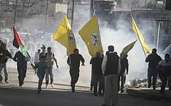 Clashes between Israeli forces and Palestinian protesters carrying Fatah flags following a rally on November 2, 2014 at the Qalandia checkpoint north of Jerusalem (photo credit: Issam Rimawi/Flash90)