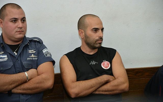 The soccer fan who burst into the field during the Hapoel Tel Aviv and Maccabi Tel Aviv game November 3 and attacked a player is brought to the Tel Aviv District Court on November 4, 2014. (photo credit: Flash90)
