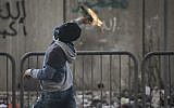 Illustrative photo of a Palestinian throwing a Molotov cocktail at Israeli forces at the entrance to the Shuafat refugee camp on November 05, 2014. (Hadas Parush/FLASH90)