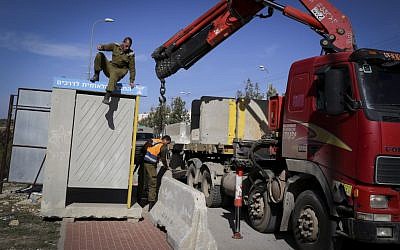 Israeli soldiers seen placing large cement blocks at a bus stop near the Jewish settlement of Alon Shvut on November 11, 2014. (Photo credit: Gershon Elinson/Flash90)