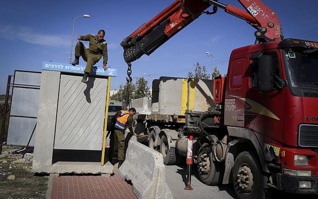 Israeli soldiers seen placing large cement blocks at a bus stop near the Jewish settlement of Alon Shvut on November 11, 2014. (Photo credit: Gershon Elinson/Flash90) Israeli soldiers seen placing large cement blocks at a bus stop near the Jewish settlement of Alon Shvut on November 11, 2014. (Photo credit: Gershon Elinson/Flash90)
