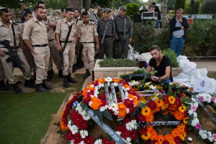 Twin brother of Israeli soldier Almog Shiloni stands by his grave at the military cemetery on Mount Herzl in Jerusalem on November 11, 2014. (photo credit: Yonatan Sindel/Flash90) Twin brother of Israeli soldier Almog Shiloni stands by his grave at the military cemetery on Mount Herzl in Jerusalem on November 11, 2014. (photo credit: Yonatan Sindel/Flash90)