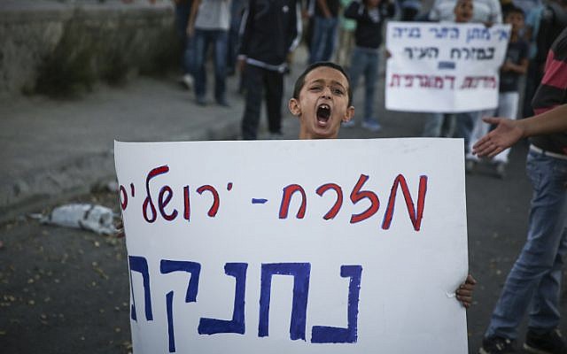 Palestinian boy marches with a sign reading 'East Jerusalem is choking,' during a demonstration in Issawiya, East Jerusalem, on November 12, 2014. (photo credit: Hadas Parush/Flash90) Palestinian boy marches with a sign reading 'East Jerusalem is choking,' during a demonstration in Issawiya, East Jerusalem, on November 12, 2014. (photo credit: Hadas Parush/Flash90)