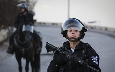 An Israeli Border Policewoman stands guard during a demonstration in Issawiya, East Jerusalem, against the new cement blockades at the entrances to the neighborhood, on November 12, 2014. (Photo credit: Hadas Parush/Flash90)