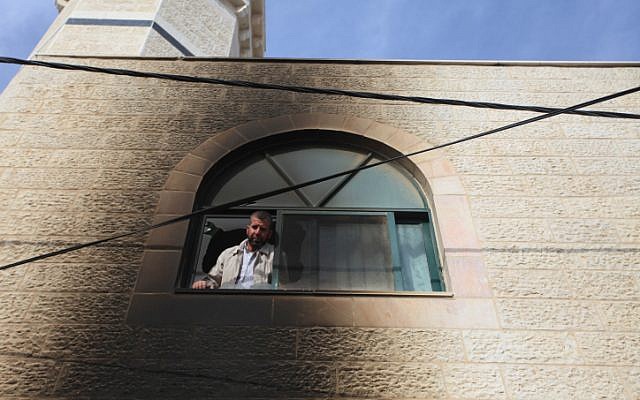 Palestinians inspect the mosque that was allegedly set on fire by Israeli settlers in al-Mughayir, in the West Bank on November 12, 2014. (photo credit: STR/Flash90)