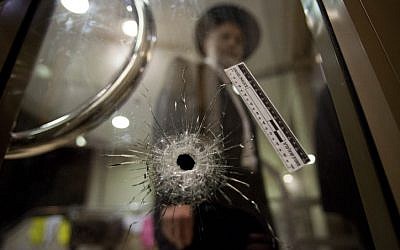 A congregant at the Har Nof synagogue where five people were killed by Palestinian terrorists examines a bullet hole. November 18, 2014. (photo credit: Noam Revkin Fenton/Flash90)
