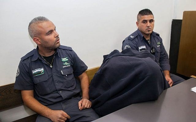 The Border Police officer, covered with shirt, accused of shooting to death a Palestinian teen on May 15 is brought to District Court in Jerusalem on November 23, 2014. (Photo credit: Yonatan Sindel/Flash90) The Border Police officer, covered with shirt, accused of shooting to death a Palestinian teen on May 15 is brought to District Court in Jerusalem on November 23, 2014. (Photo credit: Yonatan Sindel/Flash90)