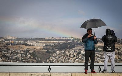 Tourists take a picture of the Old City of Jerusalem at the Armon Hanatziv lookout on a stormy winter day on Novermber 26, 2014. (Photo credit: Hadas Parush/Flash90)