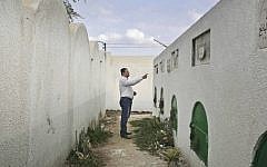 FILE - In this Wednesday, Nov. 5, 2014 file photo, Reda el-Danbouki, Egyptian lawyer for 13-year-old Sohair el-Batea who died undergoing the procedure of female genital mutilation committed by Dr. Raslan Fadl, points at her grave in Dierb Biqtaris village, on the outskirts of Aga town in Dakahliya,120 kilometers (75 miles) northeast of Cairo, Egypt. (photo credit: AP Photo/Nariman El-Mofty)
