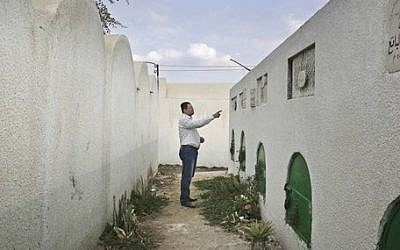 FILE - In this Wednesday, Nov. 5, 2014 file photo, Reda el-Danbouki, Egyptian lawyer for 13-year-old Sohair el-Batea who died undergoing the procedure of female genital mutilation committed by Dr. Raslan Fadl, points at her grave in Dierb Biqtaris village, on the outskirts of Aga town in Dakahliya,120 kilometers (75 miles) northeast of Cairo, Egypt. (photo credit: AP Photo/Nariman El-Mofty)