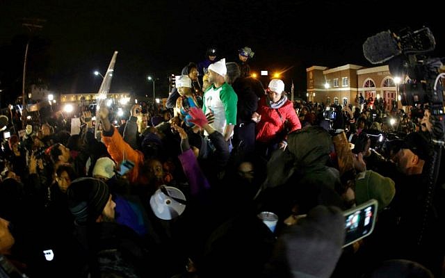 Lesley McSpadden, the mother of Michael Brown, left standing on the top of a car, reacts as she listens to the announcement of the grand jury decision Monday, Nov. 24, 2014, in Ferguson, Mo. (AP Photo/Charlie Riedel)