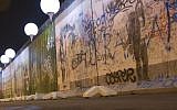 Balloons from the art project 'Lichtgrenze 2014' (lit. 'lightborder 2014') reflected in a puddle next to remains of the Berlin Wall at East Side Gallery in Berlin, Germany, Friday, November 7, 2014. (photo credit: AP/Steffi Loos)