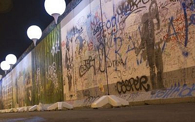 Balloons from the art project 'Lichtgrenze 2014' (lit. 'lightborder 2014') reflected in a puddle next to remains of the Berlin Wall at East Side Gallery in Berlin, Germany, Friday, November 7, 2014. (photo credit: AP/Steffi Loos)
