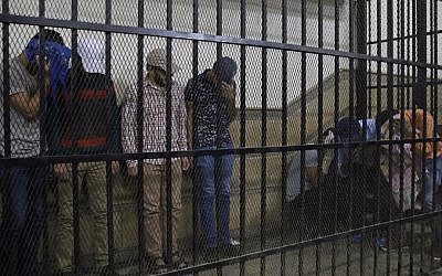 (Illustrative) Eight Egyptian men convicted for 'inciting debauchery' following their appearance in a video of an alleged same-sex wedding party on a Nile boat appear in the defendant's cage in a courtroom in Cairo, Egypt, Saturday, November 1, 2014 (Photo credit: Hassan Ammar/AP)