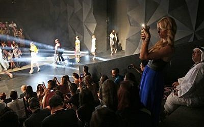 An Emirati man looks at a woman while she takes snaps of a catwalk during the "Fashion Forward" in Dubai, United Arab Emirates. Saturday, April 12, 2014 (photo credit: AP/Kamran Jebreili) An Emirati man looks at a woman while she takes snaps of a catwalk during the "Fashion Forward" in Dubai, United Arab Emirates. Saturday, April 12, 2014 (photo credit: AP/Kamran Jebreili)