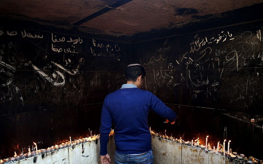 In this Thursday, Nov. 20, 2014 photo, an Iranian Jewish man lights candles at the at the tomb of Harav Oursharga, one of the holiest Jewish sites in Iran, in the city of Yazd 420 miles (676 kilometers) south of capital Tehran. (photo credit: AP Photo/Ebrahim Noroozi)