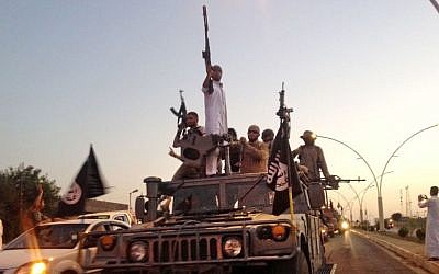 Militants from the Islamic State parade in a commandeered Iraqi security forces armored vehicle on a main street in Mosul, Iraq, Monday, June 23, 2014. (photo credit: AP, File)