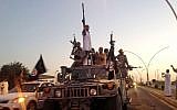 Extremists from the Islamic State on parade Monday, June 23, 2014, in a commandeered Iraqi security forces armored vehicle on a main street in Mosul, Iraq. (photo credit: AP/File)