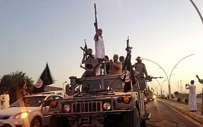 In this file photo taken Monday, June 23, 2014, militants from the Islamic State parade in a commandeered Iraqi security forces armored vehicle on a main street in Mosul, Iraq. (photo credit: AP/File) Militants from the Islamic State on parade Monday, June 23, 2014, in a commandeered Iraqi security forces armored vehicle on a main street in Mosul, Iraq. (photo credit: AP/File)