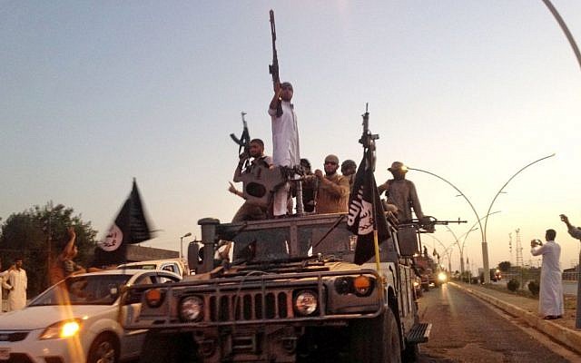 Extremists from the Islamic State on parade Monday, June 23, 2014, in a commandeered Iraqi security forces armored vehicle on a main street in Mosul, Iraq. (photo credit: AP/File) Extremists from the Islamic State on parade Monday, June 23, 2014, in a commandeered Iraqi security forces armored vehicle on a main street in Mosul, Iraq. (photo credit: AP/File)