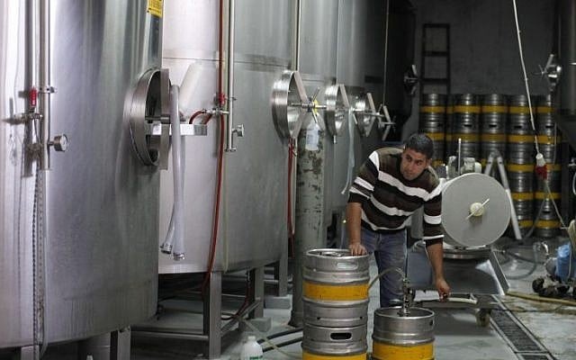 A man works at the Palestinian Taybeh brewery in Taybeh, West Bank, October 28, 2014 (Photo credit: Nasser Shiyoukhi/AP)