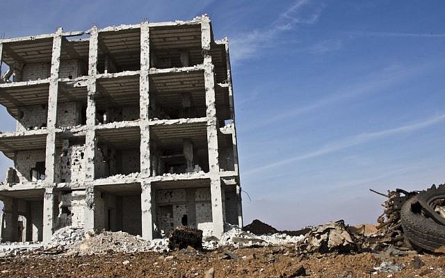 In this Wednesday, Nov. 19, 2014 photo, a destroyed building remains at the site of a truck bomb that exploded at a Kurdish People's Protection Units (YPG) stronghold. This one of the last stronghold the YPG had against Islamic State militants before the airstrikes in Kobani, Syria.(Photo credit: AP/Jake Simkin)