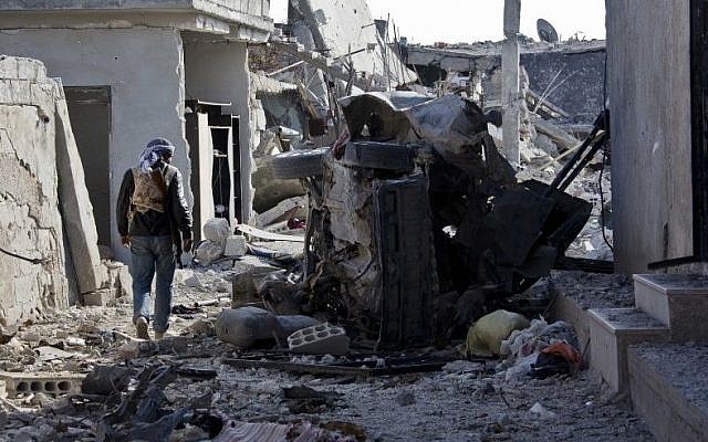 In this Wednesday, Nov. 19, 2014 photo, a Free Syrian Army fighter from Shams Al-Shamal heads to the front line in Kobani, Syria. (Photo credit: AP/Jake Simkin)