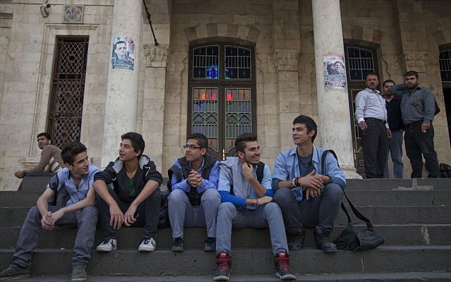 In this photo taken Sunday, Oct. 26, 2014, young men sit on the stairs of the Ottoman-era Hijaz train station in the Syrian capital, Damascus. (photo credit: AP/Diaa Hadid)