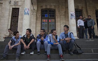 In this photo taken Sunday, October 26, 2014, young men sit on the stairs of the Ottoman-era Hijaz train station in the Syrian capital, Damascus. (photo credit: AP Photo/Diaa Hadid)