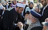 Jerusalem's chief rabbi Shlomo Amar (right, seated) shakes hands with an imam as leaders from the Christian and Muslim communities show their support outside Kehilat Yaakov Synagogue in the Jerusalem neighborhood of Har Nof, one day after two Palestinian terrorists entered the synagogue with a pistol and meat cleavers and killed four worshipers and a Druze policeman, November 19, 2014. (photo credit: Yonatan Sindel/Flash90)