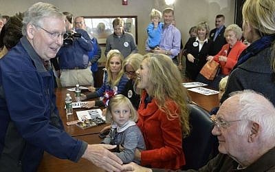 Senate Minority Leader Mitch McConnell, left, thanks supporters following a rally in Lexington, Kentucky, Monday, November 3, 2014. (photo credit: AP/Timothy D. Easley)